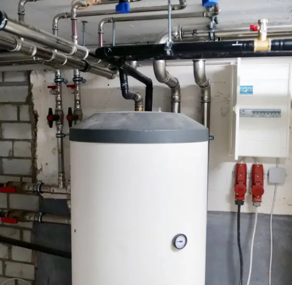 Water heater connected to overhead heating pipes in a mechanical room