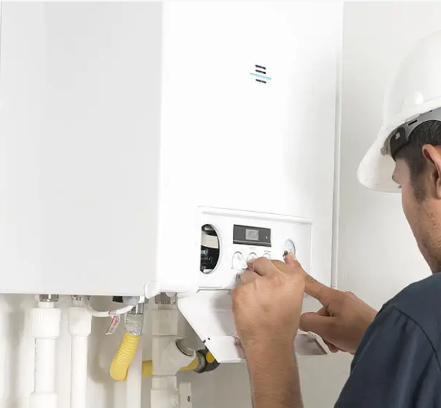 Adjusting the controls on a wall-mounted water heater during service