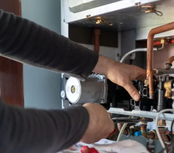 Working on the internal components of a water heater during a repair